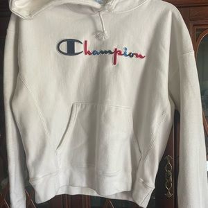 Cropped White hoodie with red and blue logo on the front.
